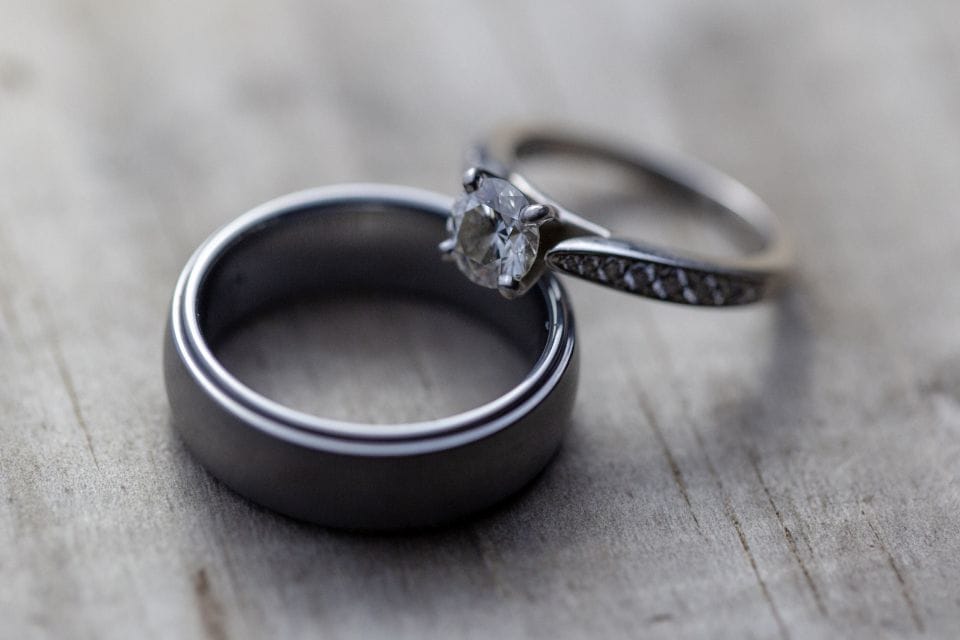 A diamond engagement ring resting on a wedding band